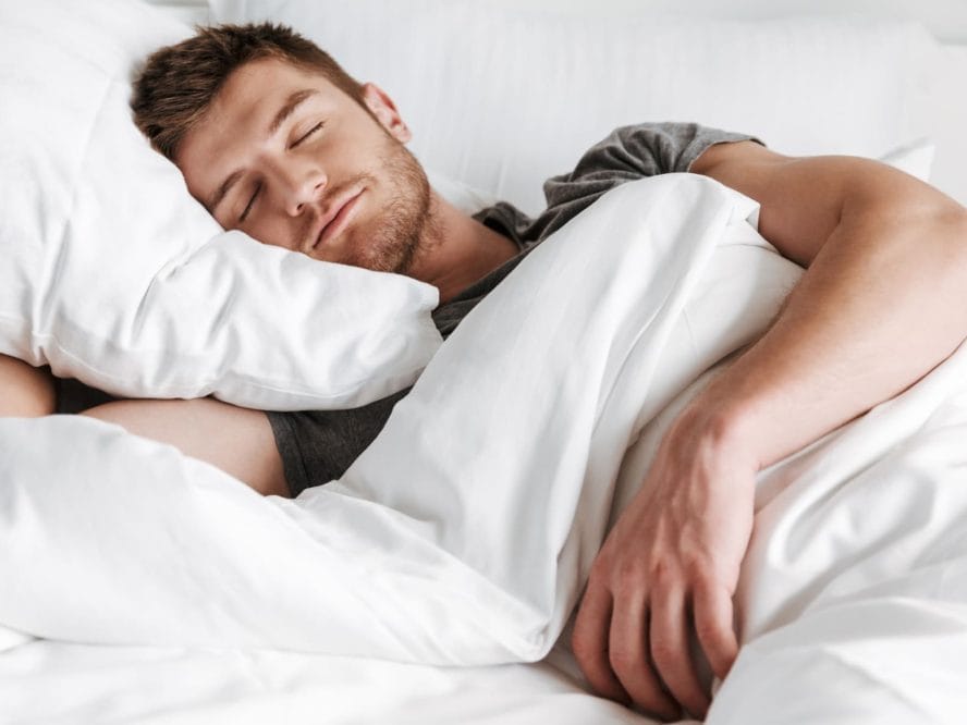 Image of a young man sleeping in bed at home