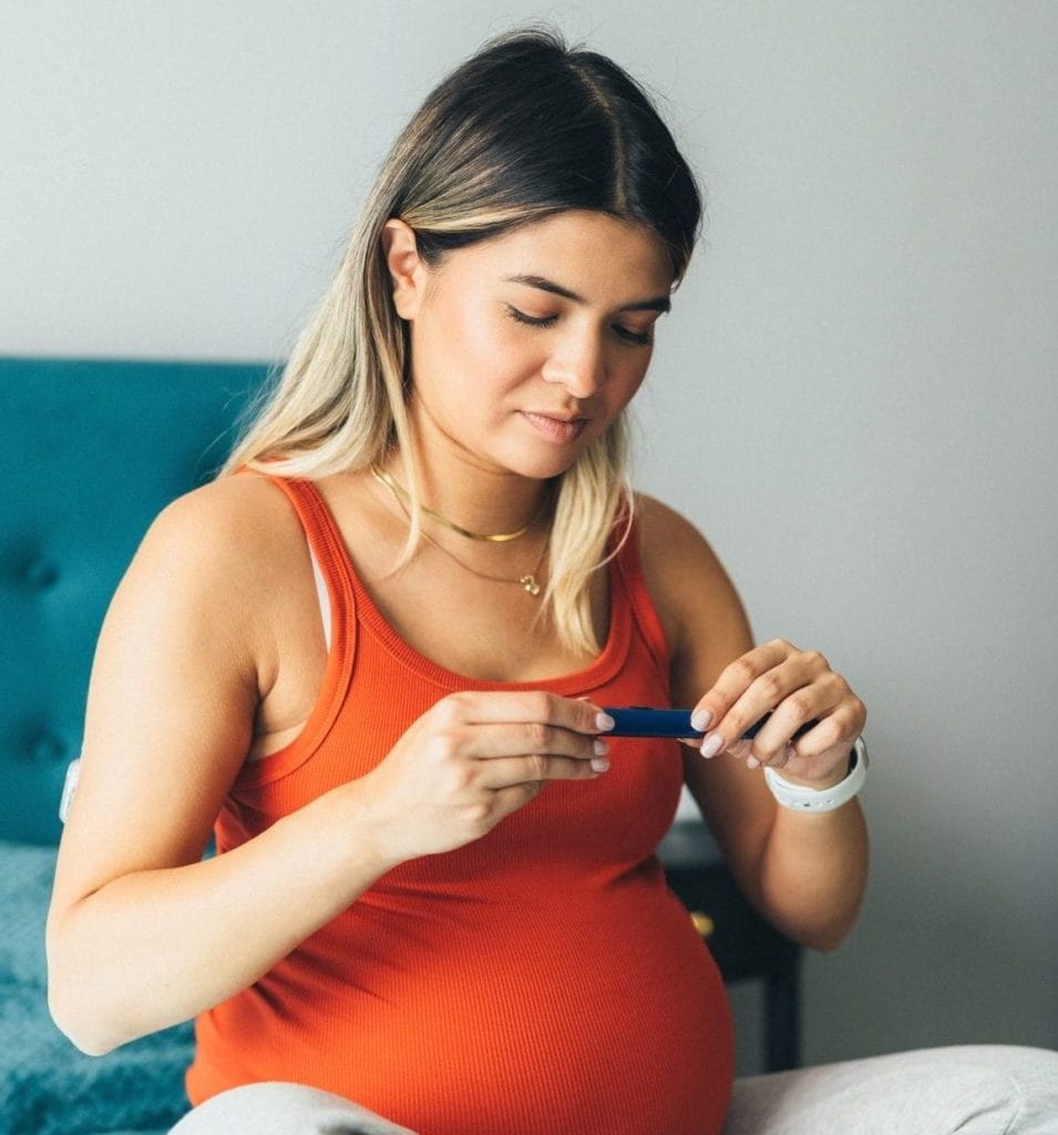 Pregnant young woman injecting insulin with insulin pen